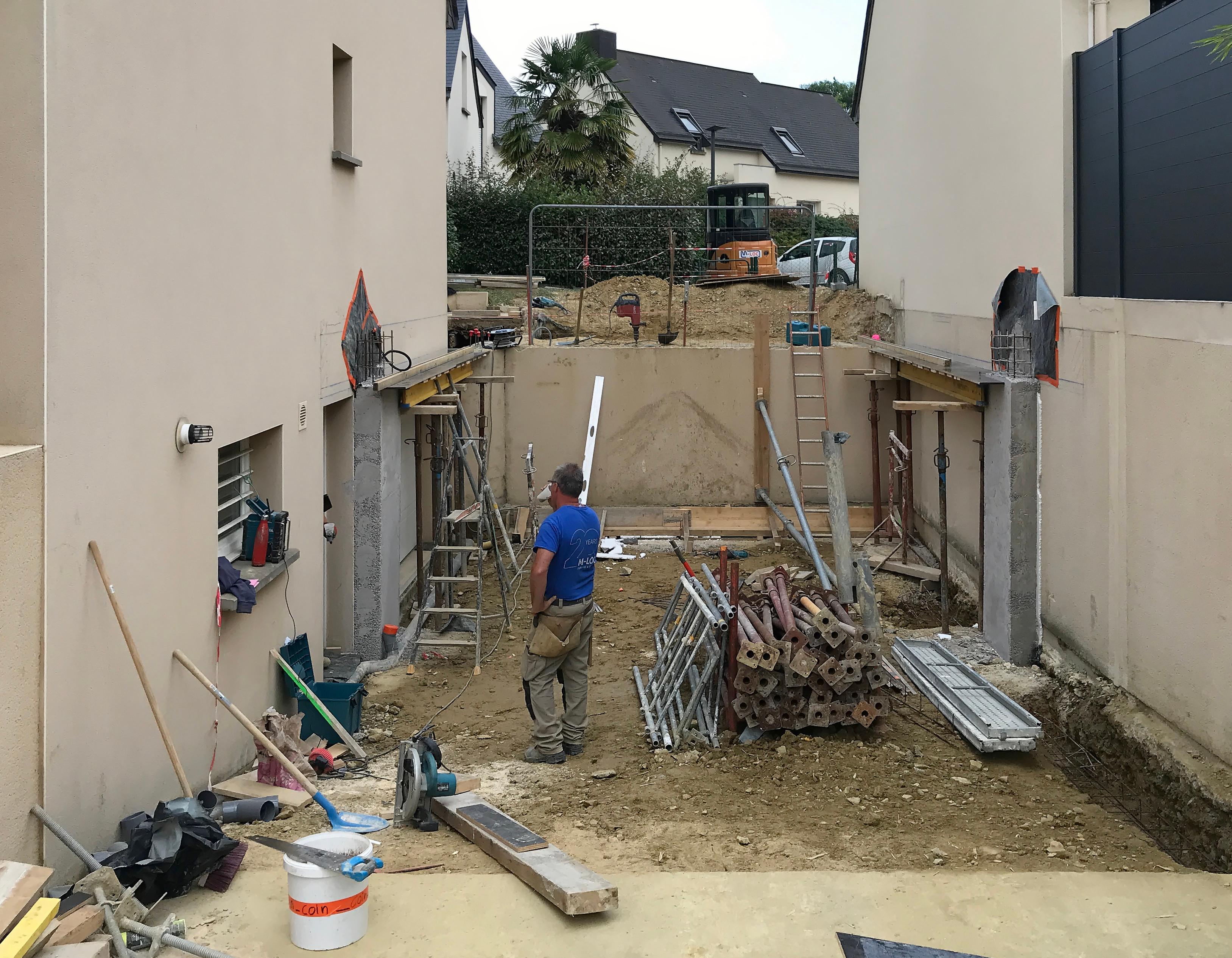 Chantier en cours : Terrassement, poteaux et poutres en béton armé.